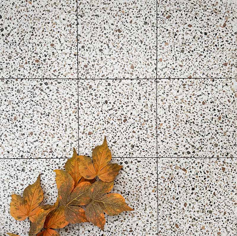 Floor installation featuring Turin Terrazzo Blanco Dots porcelain tiles in a 20 × 20cm format, laid in a neat grid pattern with subtle grout lines, showcasing the light terrazzo-style surface with scattered multicoloured stone fragments for a clean, contemporary look.