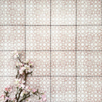 Berber Tetuan Rose 15×15cm Moroccan-style porcelain tiles laid in a grid pattern, showcasing a soft pink and cream geometric design with decorative floral styling.