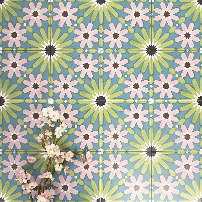 Fez Summer 20x20cm Moroccan-style porcelain wall tiles arranged in a repeating geometric pattern, featuring soft green, blue and blush pink star motifs, styled with delicate floral stems for a fresh, decorative finish.