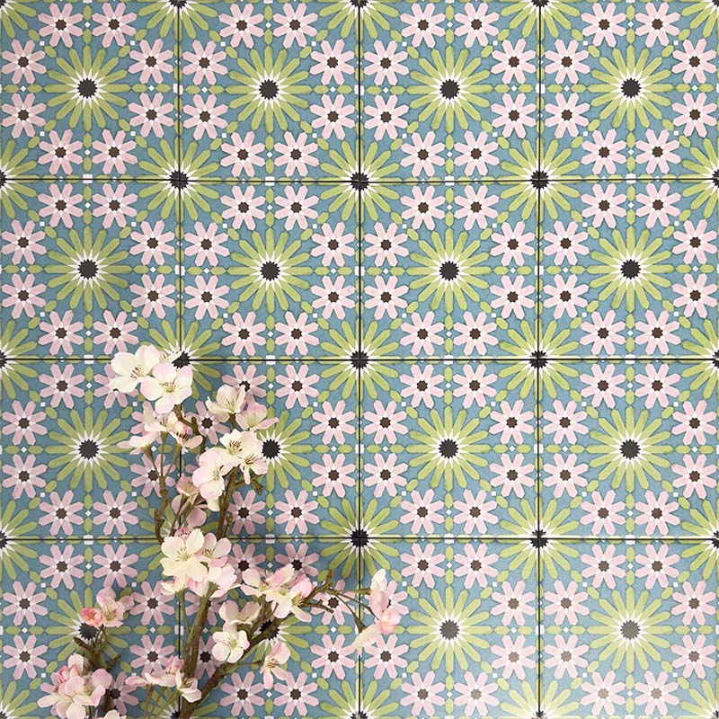 Fez Mini Summer 15x15cm Moroccan-style porcelain wall tiles arranged in a repeating geometric pattern, featuring soft green, blue and blush pink star motifs, styled with delicate floral stems for a fresh, decorative finish.