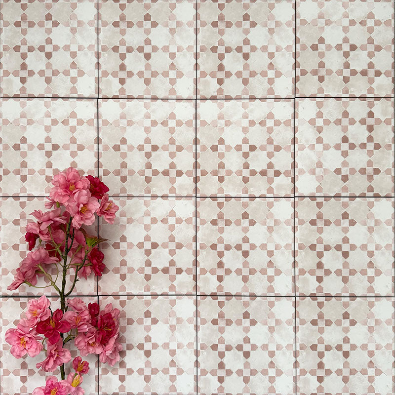 Berber Mequinez Rose 15×15cm Moroccan-style porcelain tiles laid in a grid pattern, showcasing a soft pink and cream geometric design with decorative floral styling.