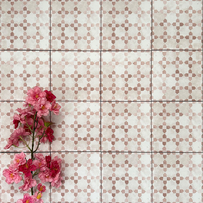 Berber Mequinez Rose 15×15cm Moroccan-style porcelain tiles laid in a grid pattern, showcasing a soft pink and cream geometric design with decorative floral styling.