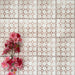 Berber Mequinez Rose 15×15cm Moroccan-style porcelain tiles laid in a grid pattern, showcasing a soft pink and cream geometric design with decorative floral styling.
