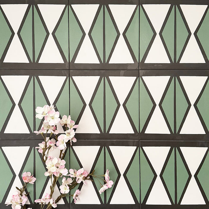 Abstract Hourglass Patterned Tiles in a 20x20cm format, displayed in a repeated grid layout to showcase the bold geometric hourglass design. Muted green and soft cream tones are framed with charcoal detailing, creating a clean, contemporary pattern ideal for feature walls, floors or decorative splashbacks.