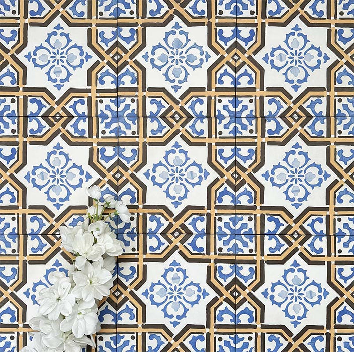 Viscount Maestro 20×20cm Victorian-style porcelain wall and floor tiles laid in a repeating ornate geometric pattern with floral detailing in blue, white and warm ochre tones, shown as a full tile layout with subtle tonal variation and floral styling.