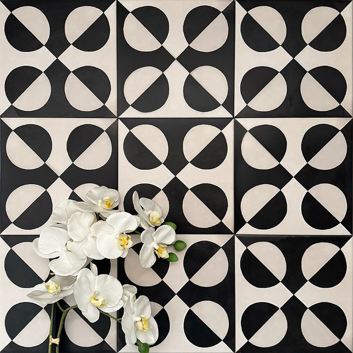 Abstract Illusion Noir Patterned Tiles in a 20x20cm format, displayed in a repeated grid layout to showcase the bold optical illusion design. High-contrast black and soft cream curved shapes create a striking geometric pattern, styled with floral accents to highlight the tiles as a statement choice for feature walls, floors or decorative splashbacks.
