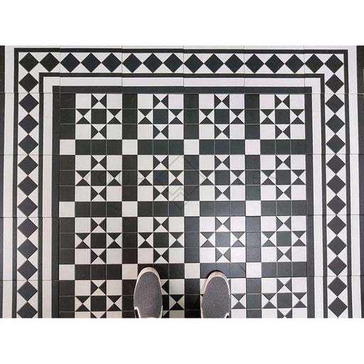 Hallway floor featuring Dorset Black & White Victorian-style porcelain tiles in a 25 × 25cm format, laid in a detailed geometric pattern and framed with matching decorative border tiles to create a classic period-style entrance floor.