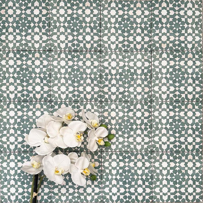 Berber Tetuan Green 15×15cm Moroccan-style porcelain tiles laid in a grid pattern, showcasing a green and cream geometric design with decorative floral styling.