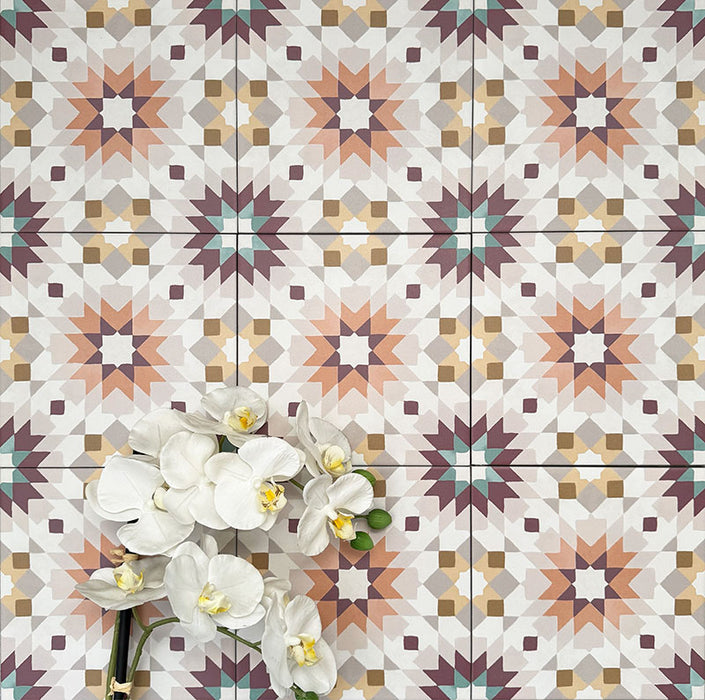 Cuba Manzanillo Moroccan-style porcelain tiles in a 20×20cm square format, arranged in a repeating geometric star pattern in soft cream, mustard, teal and burgundy tones, styled with white floral accents to highlight the tile’s decorative encaustic-style design and balanced symmetry.