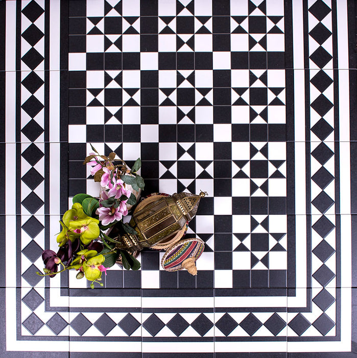 Hallway floor featuring Dorset Black & White Victorian-style porcelain tiles in a 25 × 25cm format, laid in a detailed geometric pattern with coordinating border and corner tiles to create a striking framed design with classic black and white contrast.
