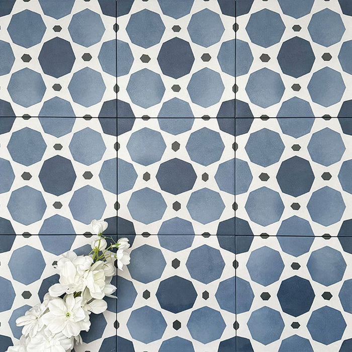 Viscount Sapphire 20×20cm Victorian-style porcelain wall and floor tiles laid in a repeating blue and white geometric pattern, shown as a full tile layout with octagonal motifs and subtle tonal variation, styled with white floral accents.