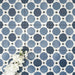 Viscount Sapphire 20×20cm Victorian-style porcelain wall and floor tiles laid in a repeating blue and white geometric pattern, shown as a full tile layout with octagonal motifs and subtle tonal variation, styled with white floral accents.