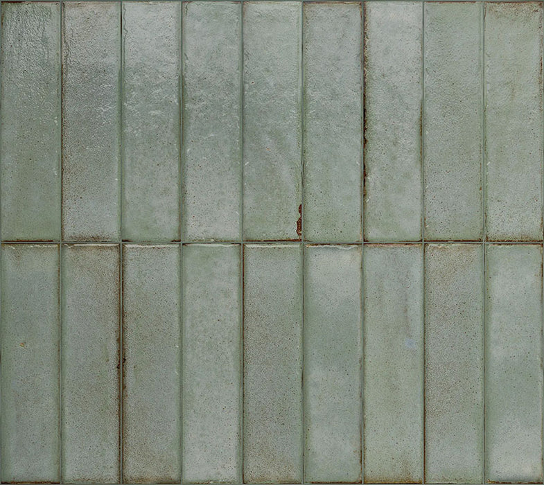 Puzzle Sage Green Brick Rectified 5x20cm porcelain tiles displayed in a full layout, showcasing soft sage green tones with gentle speckling and natural shade variation across each brick. The rectified edges create clean, uniform lines, while the subtle surface texture adds depth and a refined handmade aesthetic to both wall and floor installations.