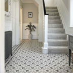 Hallway featuring Canterbury Star Victorian-style porcelain floor tiles in a 20 × 20cm format, laid in a repeating geometric star pattern with a decorative border, paired with a carpeted staircase, traditional panelling and classic period details for a timeless entrance.