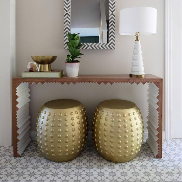 Agadir Silver Moroccan-style 20x20cm porcelain tiles used on a hallway floor, featuring a soft grey geometric pattern paired with a wooden console table, gold stools, and neutral décor for an elegant entrance space.