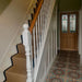 Hallway interior featuring London Streets Hanover Square 20x20cm Victorian Moroccan style floor tiles, styled with a traditional staircase, herringbone stair runner, white balustrade and stained glass front door for a classic entrance hallway.