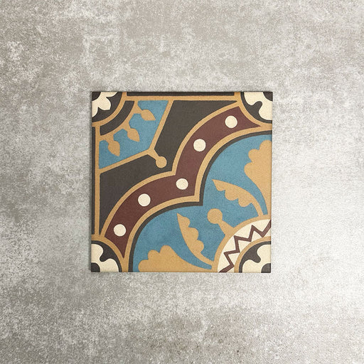 Single London Streets Hanover Square 20x20cm Victorian Moroccan style porcelain tile displayed in a product setting, featuring an ornate geometric pattern in blue, terracotta, cream and dark brown tones inspired by traditional decorative floor tiles.