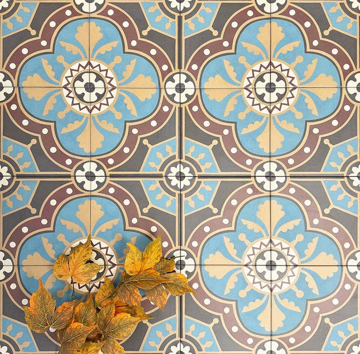 Group of London Streets Hanover Square 20x20cm Victorian Moroccan style porcelain tiles arranged to display the repeating blue, terracotta and cream geometric pattern, styled with autumn leaves for a decorative flat-lay tile setting.