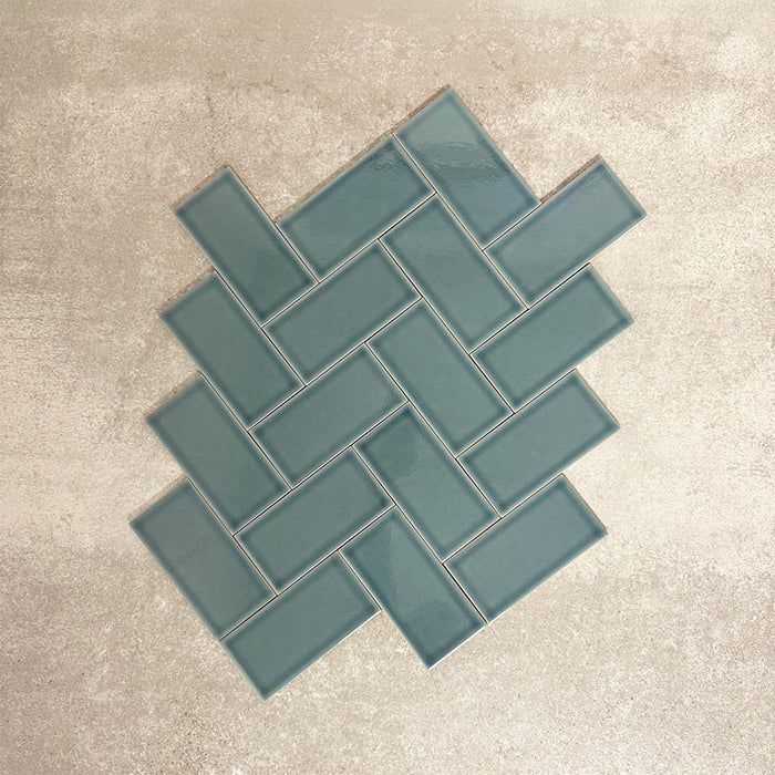Pimlico River Blue 7.5 × 15cm ceramic wall tiles with a crackle glaze finish, shown in a herringbone layout that highlights deep blue tones, subtle texture and versatile design options for kitchens and bathrooms.