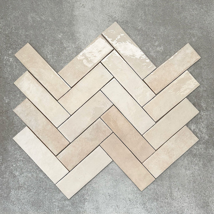 Zellige Bone Moroccan-style brick tiles in a warm beige tone, shown in a simple herringbone layout.