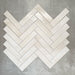 Allegra Blanca Gloss Brick ceramic tiles in a 6 × 25cm format, arranged in a herringbone pattern to showcase the glossy white finish and subtle handmade-style variation.