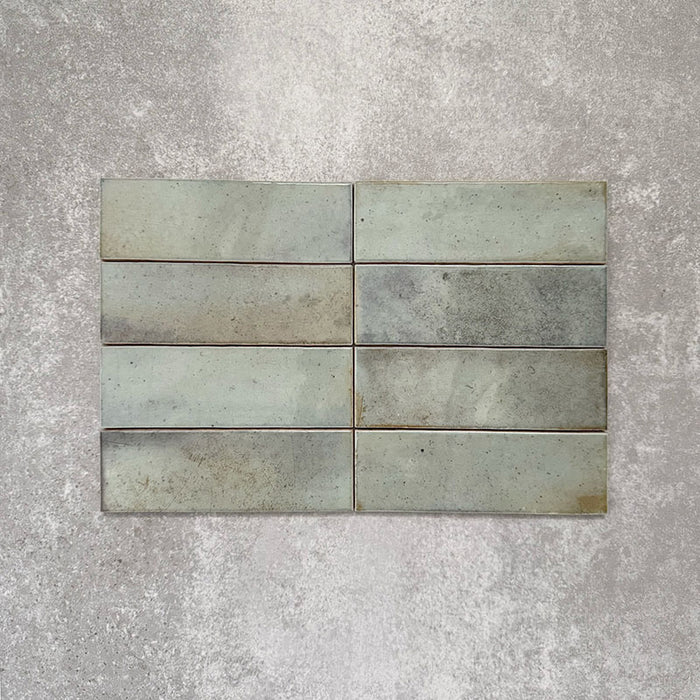 Saigon Celadon Green Brick Wall tiles laid horizontally, featuring Moroccan-style 5.1 × 16.1cm glossy ceramic tiles with soft green and blue-grey tonal variation.