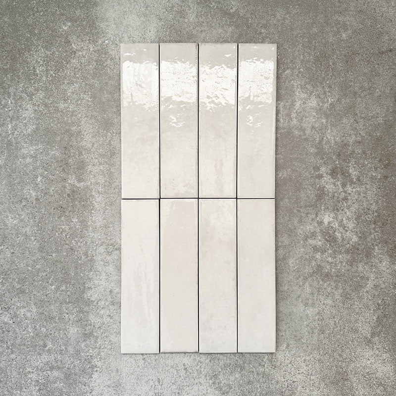 Nomad White brick wall tiles in a 6 × 24.6cm format, shown laid together to highlight the soft white colour, gloss finish and subtle surface variation.