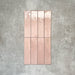 Nomad Rose brick wall tiles in a 6 × 24.6cm format, shown laid together to highlight the soft pink tone, gloss finish and subtle surface variation.