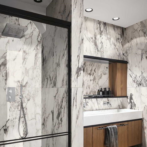Bathroom interior featuring Hudson Capraia Matt Marble 60 × 120cm porcelain wall tiles, showcasing a crisp white base with bold, dramatic grey veining, paired with black-framed shower detailing and warm wood cabinetry for a striking, contemporary contrast.