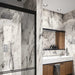 Bathroom interior featuring Hudson Capraia Matt Marble 60 × 120cm porcelain wall tiles, showcasing a crisp white base with bold, dramatic grey veining, paired with black-framed shower detailing and warm wood cabinetry for a striking, contemporary contrast.