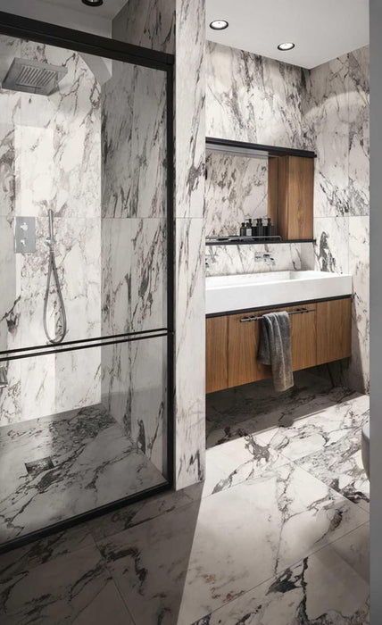 Bathroom interior featuring Hudson Capraia Matt Marble 60 × 120cm porcelain wall tiles, showcasing a crisp white base with bold, dramatic grey veining, paired with black-framed shower detailing and warm wood cabinetry for a striking, contemporary contrast.