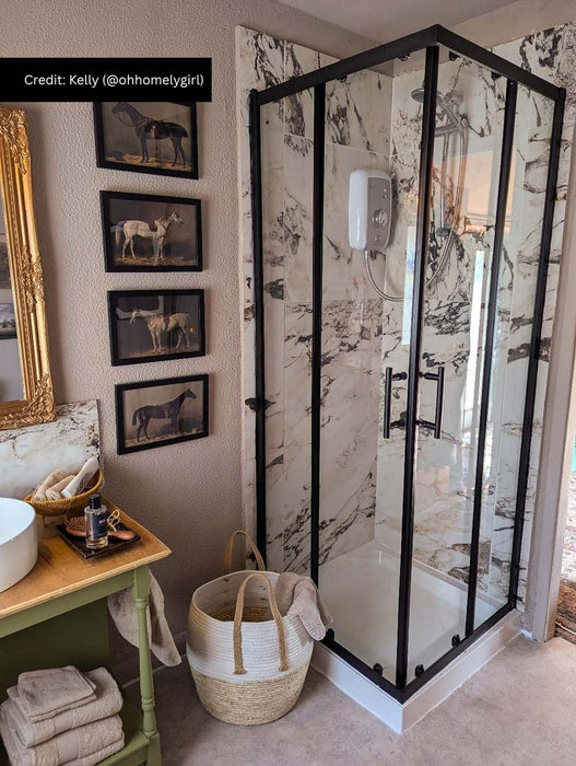 Customer bathroom featuring Hudson Capraia matt marble effect porcelain tiles in a walk-in shower. Large-format 60cm x 60cm white marble effect wall tiles with bold grey veining are paired with a black framed shower enclosure, creating a timeless and elegant bathroom design.