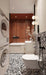 Bathroom setting featuring Shards Terrazzo Nero 59x59cm matt porcelain wall and floor tiles, showcasing a bold terrazzo effect with large white stone fragments set against a deep black base, used across both floor and feature wall, paired with crisp white sanitaryware, warm terracotta tones and soft lighting for a balanced, contemporary contrast.