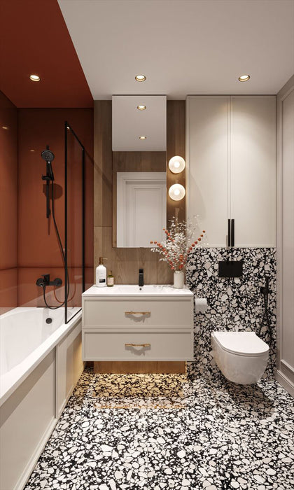 Bathroom setting featuring Shards Terrazzo Nero 59x118cm matt porcelain wall and floor tiles, showcasing a bold black base with contrasting white aggregate, paired with warm wood finishes, soft lighting and deep terracotta shower walls.