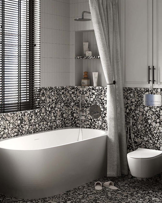 Bathroom setting featuring Shards Terrazzo Nero 59x59cm matt porcelain wall and floor tiles, showcasing a bold terrazzo effect with large white stone fragments set against a deep black base, used across the lower walls and floor to create a cohesive, statement look, paired with vertical white wall tiles, soft textiles and contemporary fittings for a balanced, modern finish.