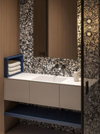 Bathroom setting featuring Shards Terrazzo Nero 59x118cm matt porcelain wall and floor tiles, showcasing a bold black base with contrasting white aggregate, paired with warm wood cabinetry, matte black fittings and soft ambient lighting.