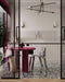Dining space featuring Shards Terrazzo Nero 59x59cm matt porcelain floor tiles, showcasing a bold terrazzo effect with large white stone fragments set against a deep black base, used across the floor to anchor the space, paired with sculptural furniture, soft neutral cabinetry and striking red accents for a refined, contemporary contrast.