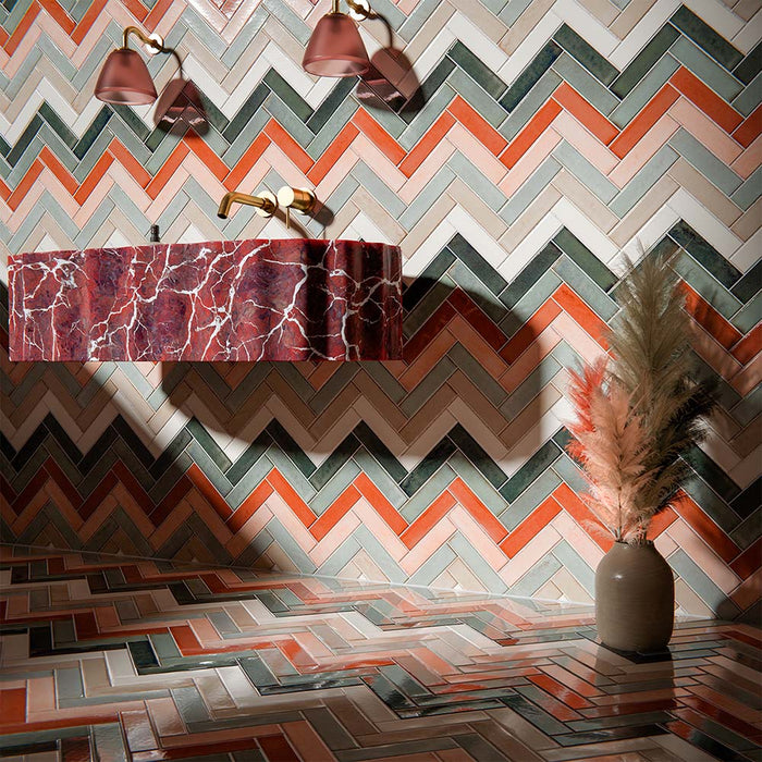 Bathroom interior featuring Puzzle Collection gloss brick tiles, installed in a bold herringbone pattern across walls and floor, blending warm terracotta, soft blush, sage green and cream tones for a statement finish.