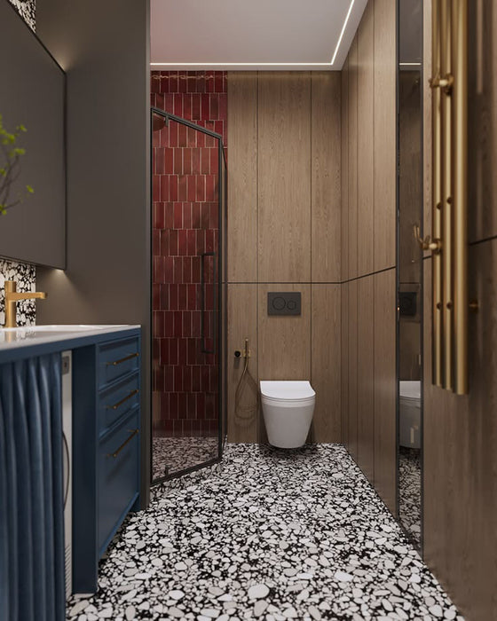 Bathroom setting featuring Shards Terrazzo Nero 59x118cm matt porcelain wall and floor tiles, showcasing a bold black base with contrasting white aggregate, paired with deep red brick tiles, blue cabinetry and brass fittings for a striking, contemporary finish.