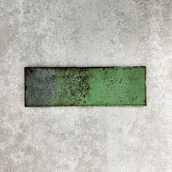 Close-up of Foundry Bricks Jade Green 6.5x20cm brick wall tile, showcasing varied green tones with rich tonal variation, lightly textured surface and gently irregular edges for a refined, contemporary finish.