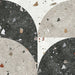 Flat lay of Jericho Decor Terrazzo 66 × 66cm porcelain wall and floor tile, featuring a terrazzo base with multicoloured aggregate chips combined with bold geometric quarter-circle patterning in contrasting light and dark tones, creating a striking, contemporary statement design.