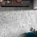 Top-down interior view featuring Jericho Silver Terrazzo 66 × 66cm porcelain wall and floor tiles, showcasing a soft grey base scattered with multicoloured aggregate chips, styled with modern furnishings for a clean, contemporary finish.