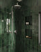 Walk-in shower featuring Jumairah Pine Forest Green 5 × 40cm gloss ceramic wall tiles, laid vertically with deep green tonal variation, paired with chrome shower fittings, recessed niches, and a clean, modern layout.