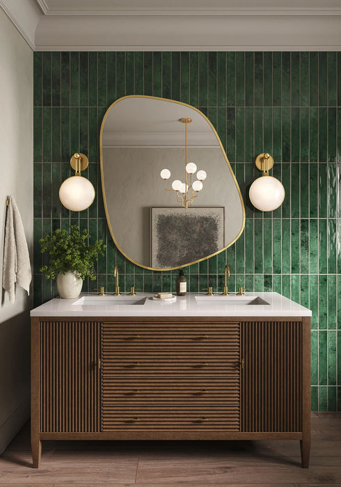 Bathroom vanity featuring Jumairah Pine Forest Green 5 × 40cm gloss ceramic wall tiles, laid vertically with deep green tonal variation, paired with a wooden vanity unit, brass fittings, twin basins, and statement mirror.