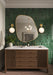 Bathroom vanity featuring Jumairah Pine Forest Green 5 × 40cm gloss ceramic wall tiles, laid vertically with deep green tonal variation, paired with a wooden vanity unit, brass fittings, twin basins, and statement mirror.