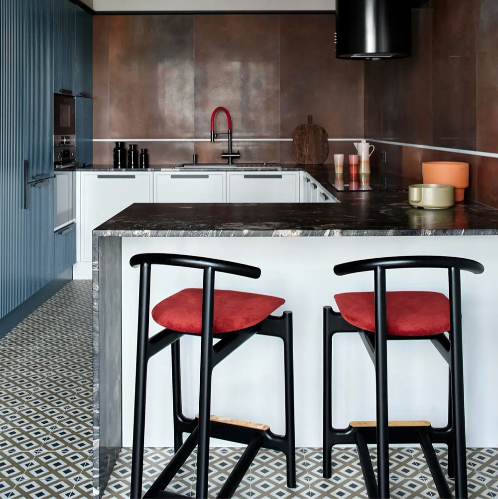 Kitchen setting featuring Viscount Park Road 20x20cm Victorian style wall and floor tiles, showcasing a repeating geometric pattern in soft grey and white tones, paired with rich brown wall tiles, dark worktops and contemporary cabinetry for a bold, design-led finish.