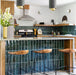 Nairobi Gloss Blue 7.5x30cm handmade-effect porcelain tiles installed as a vertical kitchen splashback and island feature, showcasing rich blue-green tones with natural shade variation and a glossy, rustic surface. The elongated format enhances height and texture, pairing beautifully with warm wood cabinetry, brass accents and contemporary interiors.