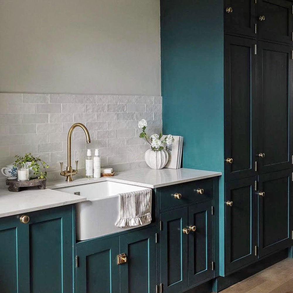 Kitchen featuring Zellige Oyster Brick Moroccan-style ceramic wall tiles in a 6.5 × 20cm brick format, laid in a horizontal pattern as a splashback and paired with deep green cabinetry, brass fixtures and light worktops for a warm, characterful kitchen finish.