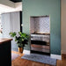 Kitchen interior featuring London Streets Thornton Place 20x20cm Victorian Moroccan style porcelain tiles used as a decorative splashback and floor detail around a range cooker, showcasing a classic blue and white patterned tile design against soft green walls and natural wood flooring.