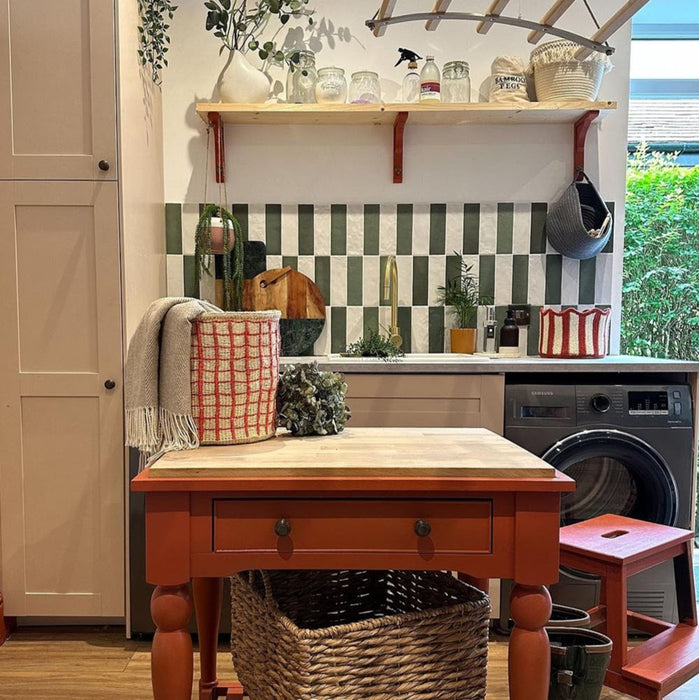 Kitchen featuring Zellige Malachite Green 6.5×20cm Moroccan-style ceramic brick tiles used as a splashback, arranged in a checkerboard pattern with cream tiles and styled with wooden shelving, brass tapware and warm neutral cabinetry.